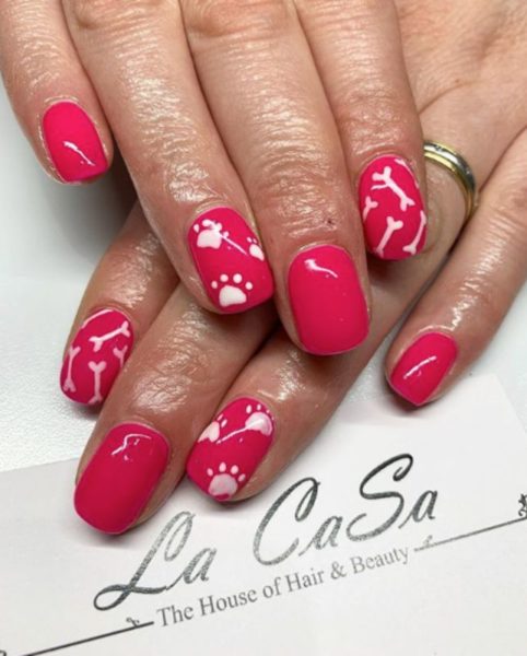 White paw prints and bones decorate this short red set by @nailsbylauren1992