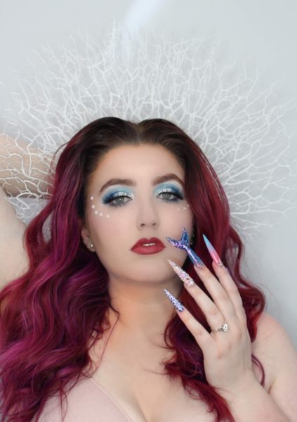 Olivia Collins
"Being a young nail tech in a small town has its challenges. I don’t often get to express myself with nail art so I took this opportunity to push myself way past my limits. This is me. I’ve never sculpted nails on myself past a number 1... these are a 4.5 which I definitely struggled with. I’ve never made any shapes out of acrylic so I tried to do my best with a mermaid tail. I don’t hand paint so I freehanded some scales, I’ve never done a full Swarovski crystal nail before but I did it. I find it hard to express myself in a small town sometimes but I think I exceeded all of my own personal expectations with this project."