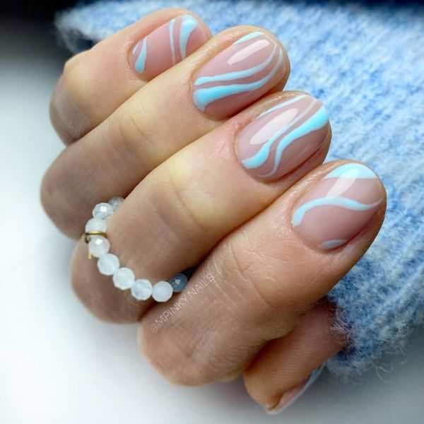 @mpinky.nails uses pastel blue swirls to add a pop of colour to a subtle nude base. 