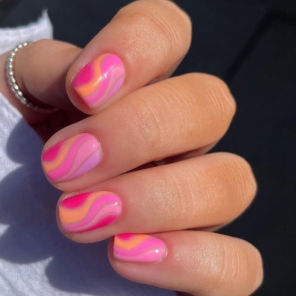 @thenailroommanchester uses a range of bold hues for this negative space swirl style. 