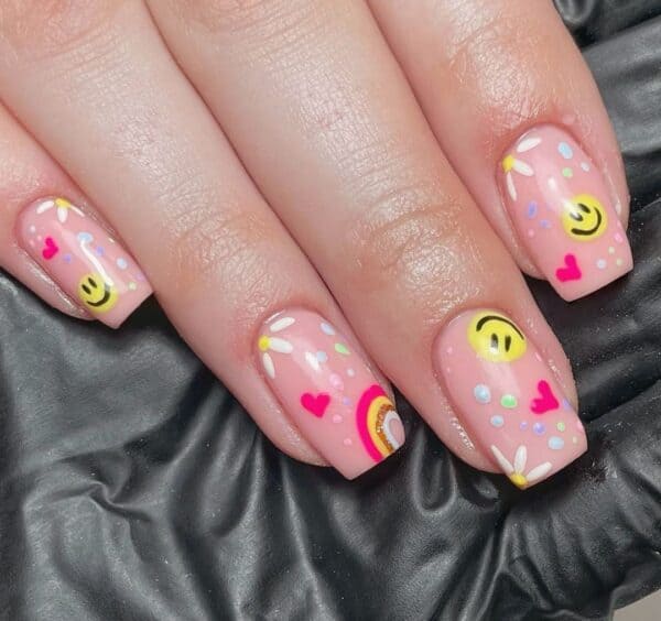 Rainbows and flowers complement this smiley style by @emmap_nailtechnician. 