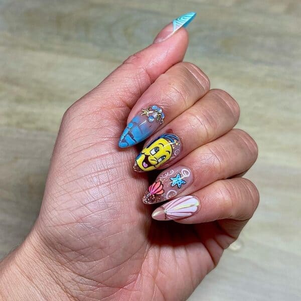 @kittycatclaws_239 keeps it bright and fun with this Flounder-themed nail art. 