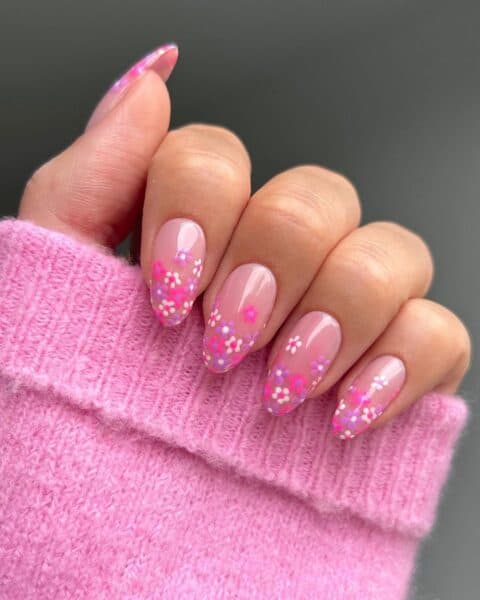 Nail content creator, @thenaillologist, channels Barbie with pretty pink, purple and white flowers at the tip of each nail.