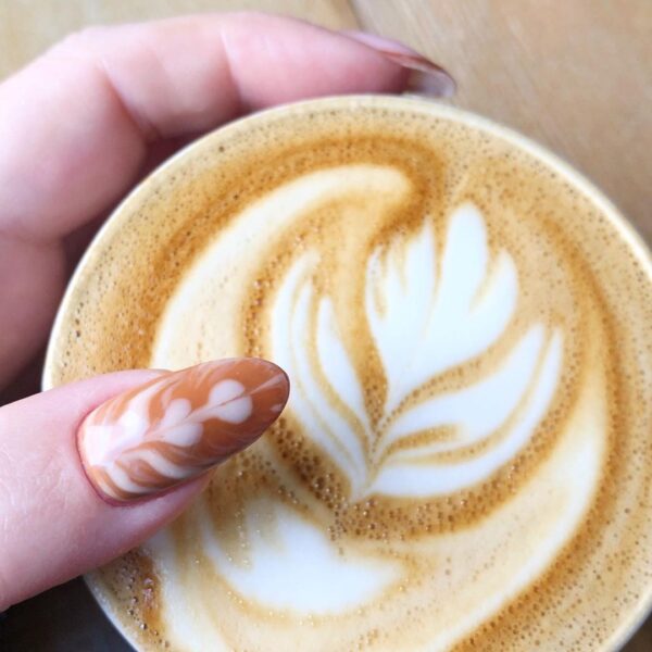 Jen Seales of @swaknails mirrors her intricate latte art on her thumb, for an eye-catching nail design.