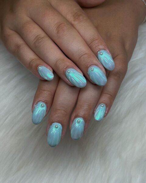 Jenna Roth of @blossomnailsbyjenna fashions textured blue oyster nails.