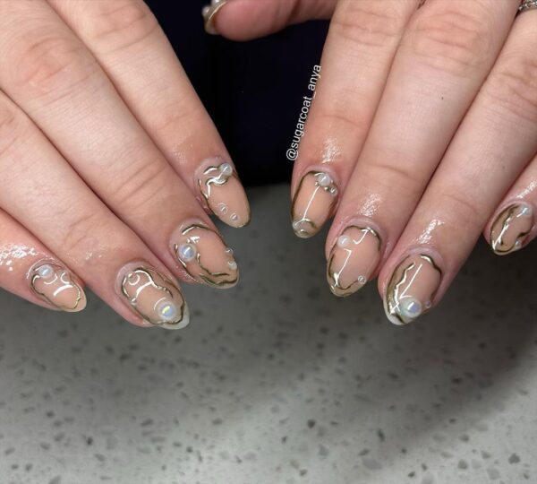 Abstract chrome details frame nails and complement pearl elements in @sugarcoat_anya's design.
