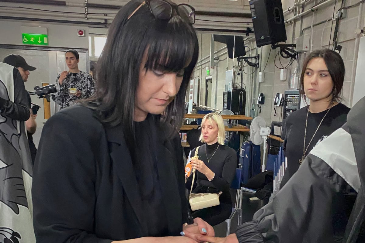 Nail professional styling nails backstage during a session for beauty and salon industry inspiration.